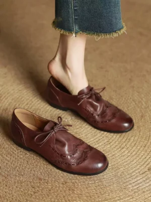 Women's brown leather casual Oxford brogue shoes worn with cropped frayed denim jeans in a relaxed Korean streetwear outfit