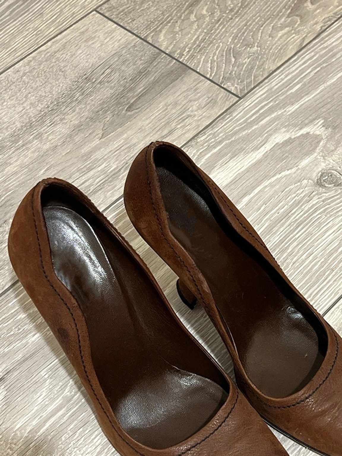 Top view of brown sculpted heel round-toe pumps with dark brown insoles and matte leather-look uppers