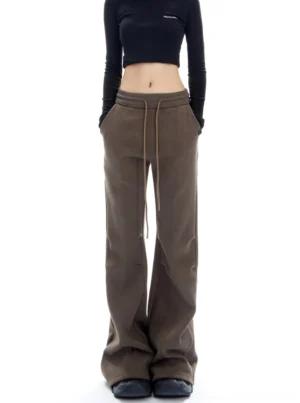 Brown wide-leg flared streetwear pants with front pockets and adjustable drawstring waist styled with a black cropped top