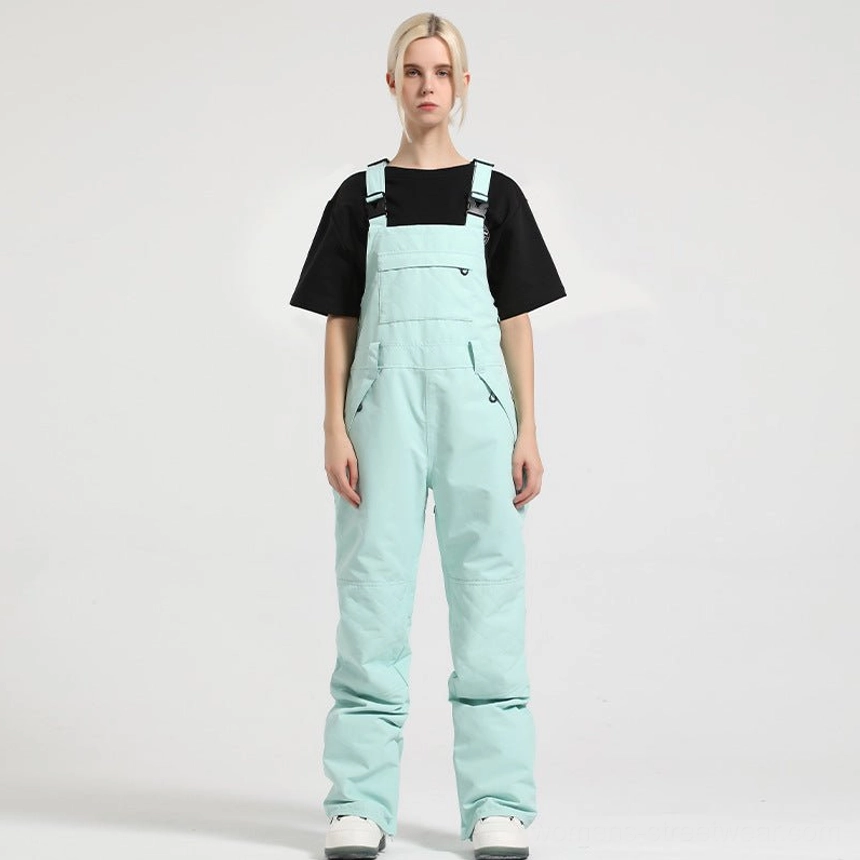 Women's colorblock bib snow pants with adjustable straps, utility pockets, waterproof shell, and relaxed streetwear fit