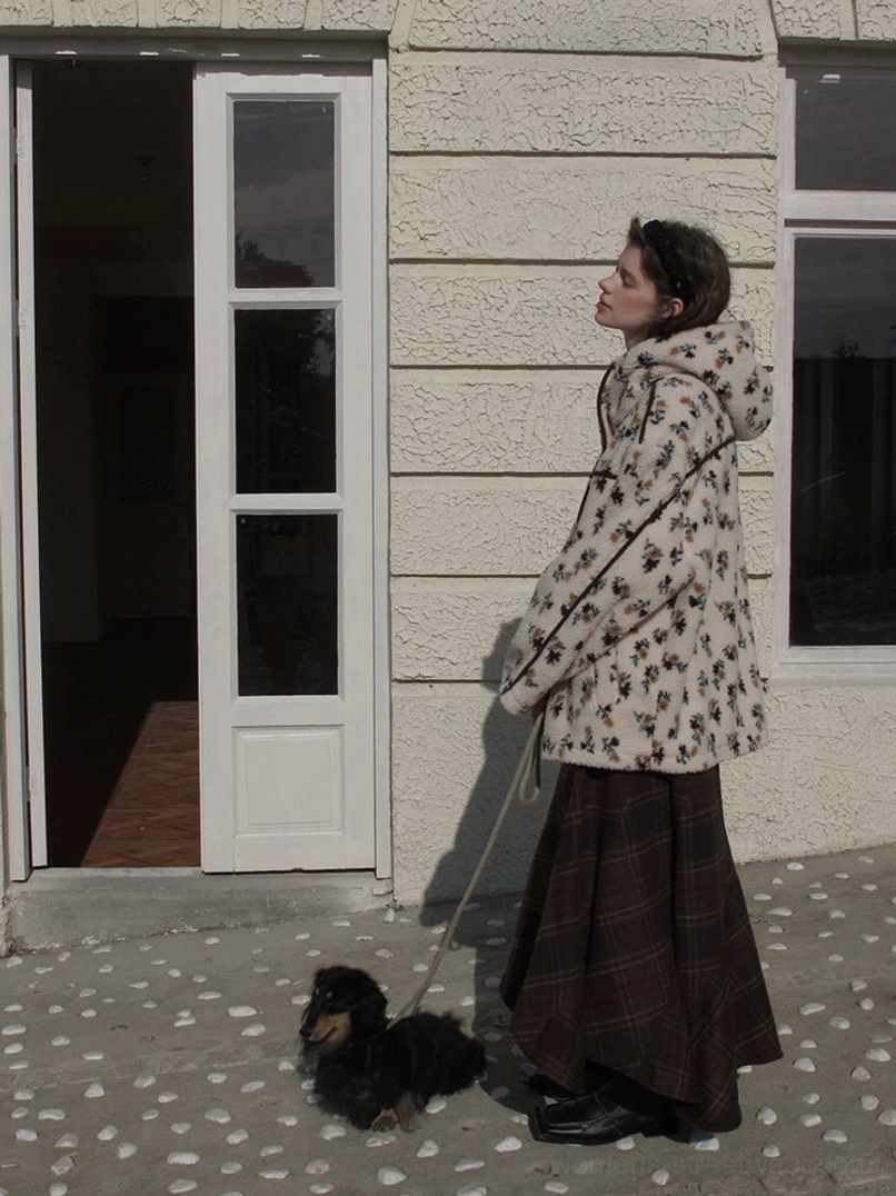 Side view of women's cream floral print sherpa jacket with hood and black contrast piping