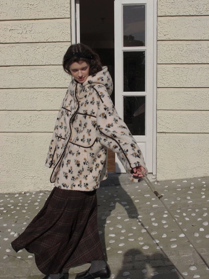 Women's cream floral print sherpa hooded jacket with black contrast piping shown from the rear outdoors