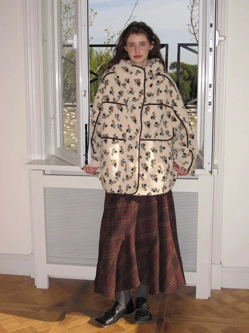 Full-length view of women's cream floral sherpa hooded jacket paired with a dark plaid midi skirt