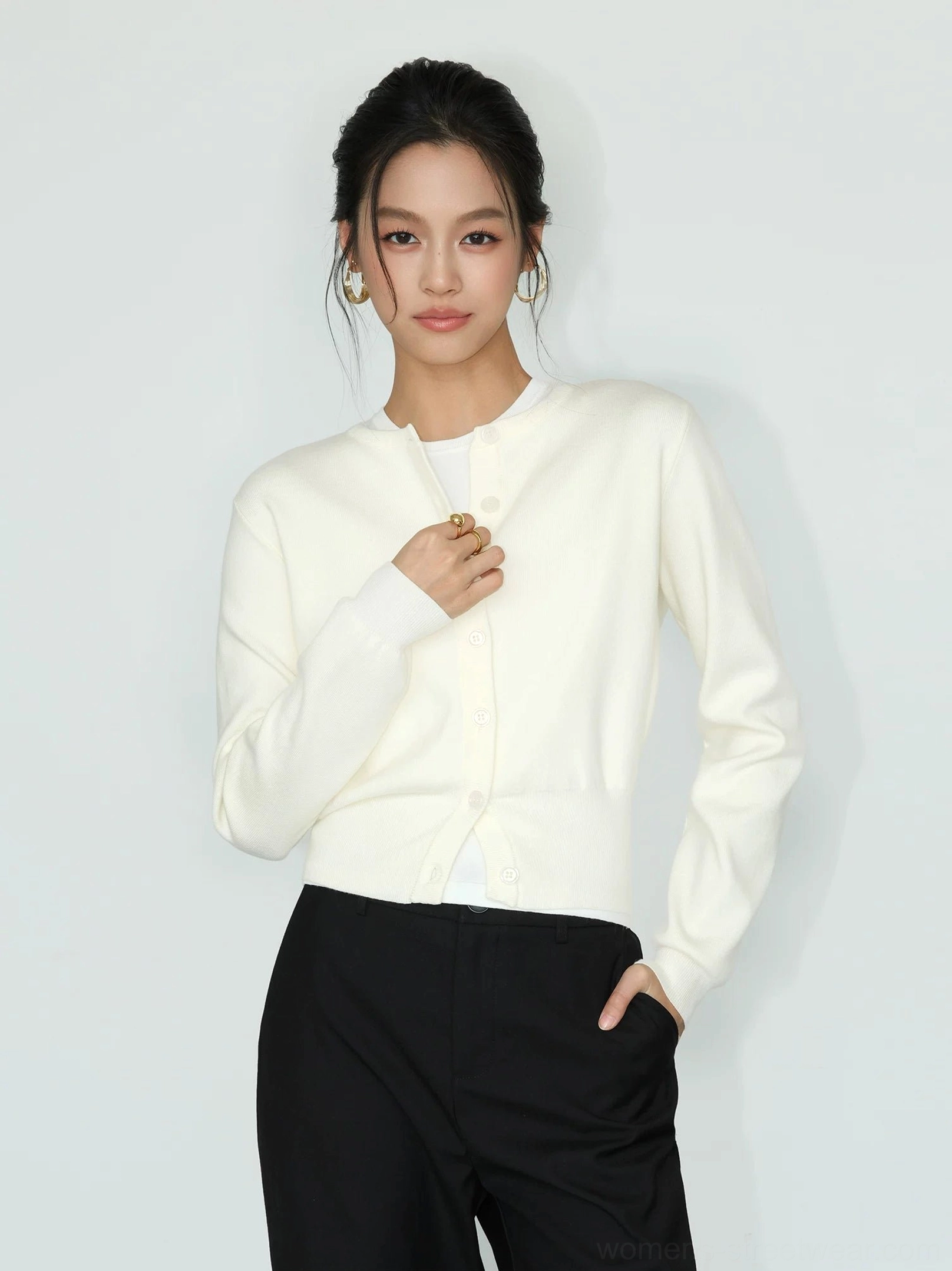Light apricot women's cropped crew neck button front knit cardigan in a three-quarter front studio view