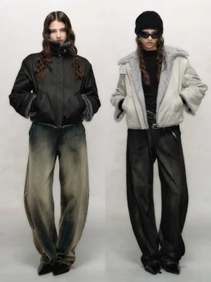 Women's cropped faux fur winter bomber jackets shown in black and gray with stand collars and plush trim in a minimalist studio