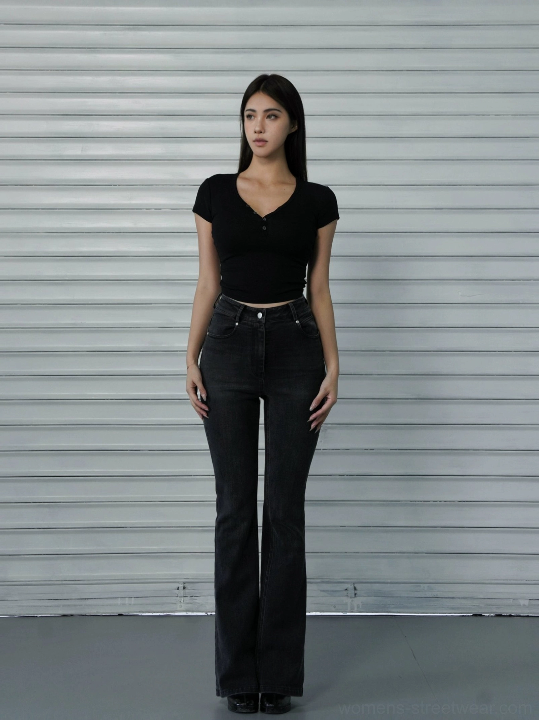 Black women's cropped Henley baby tee with button placket and narrow shoulders styled with flared jeans