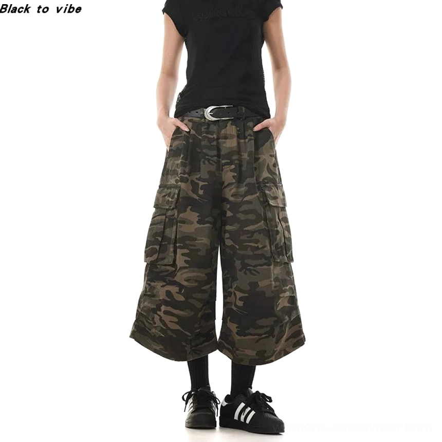 Women’s cropped washed camo wide leg cargo pants paired with black crop top silver belt and sneakers