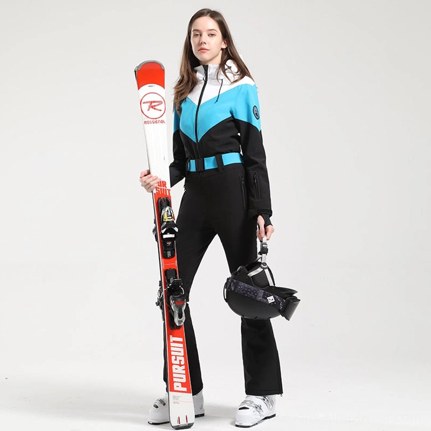 Women's cyan black white colorblock ski suit shown from a three-quarter view with flared black pants cyan waist belt skis and helmet