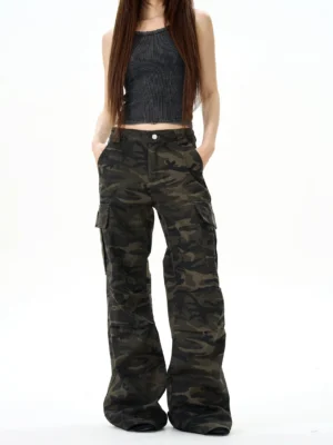 Front view of women’s dark camo streetwear cargo pants with hands in pockets showing the relaxed wide-leg fit and utility pocket design