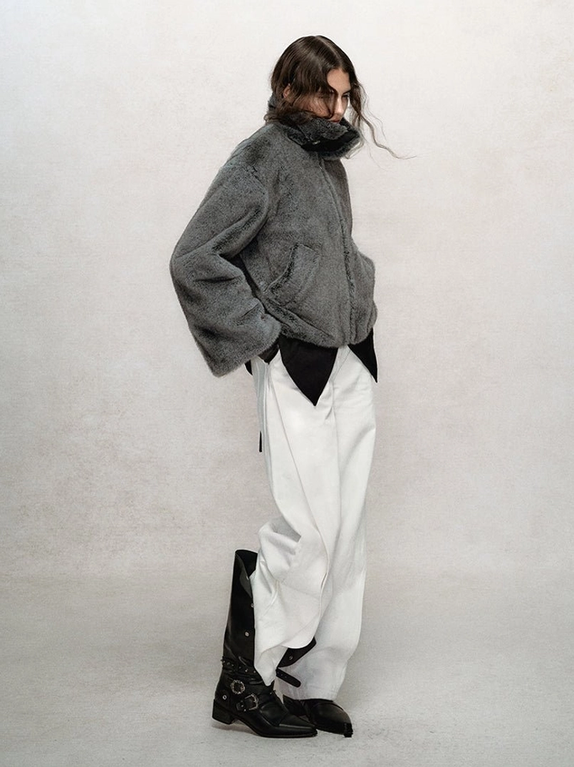 Women's dark gray cropped faux fur bomber jacket shown in side profile with stand collar, relaxed fit, and practical side pockets