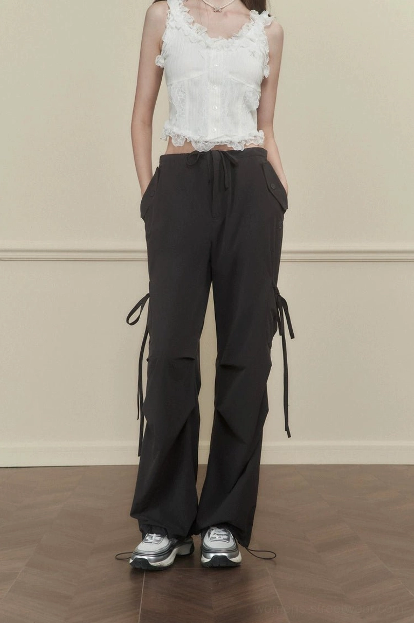 Women's dark gray loose wide-leg cargo pants with hanging side ties and drawstring waist in a Korean streetwear outfit