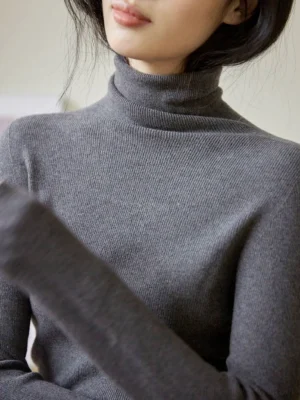 Dark gray ribbed mock neck knit sweater for women shown in a close front upper body view with a slim fitted silhouette