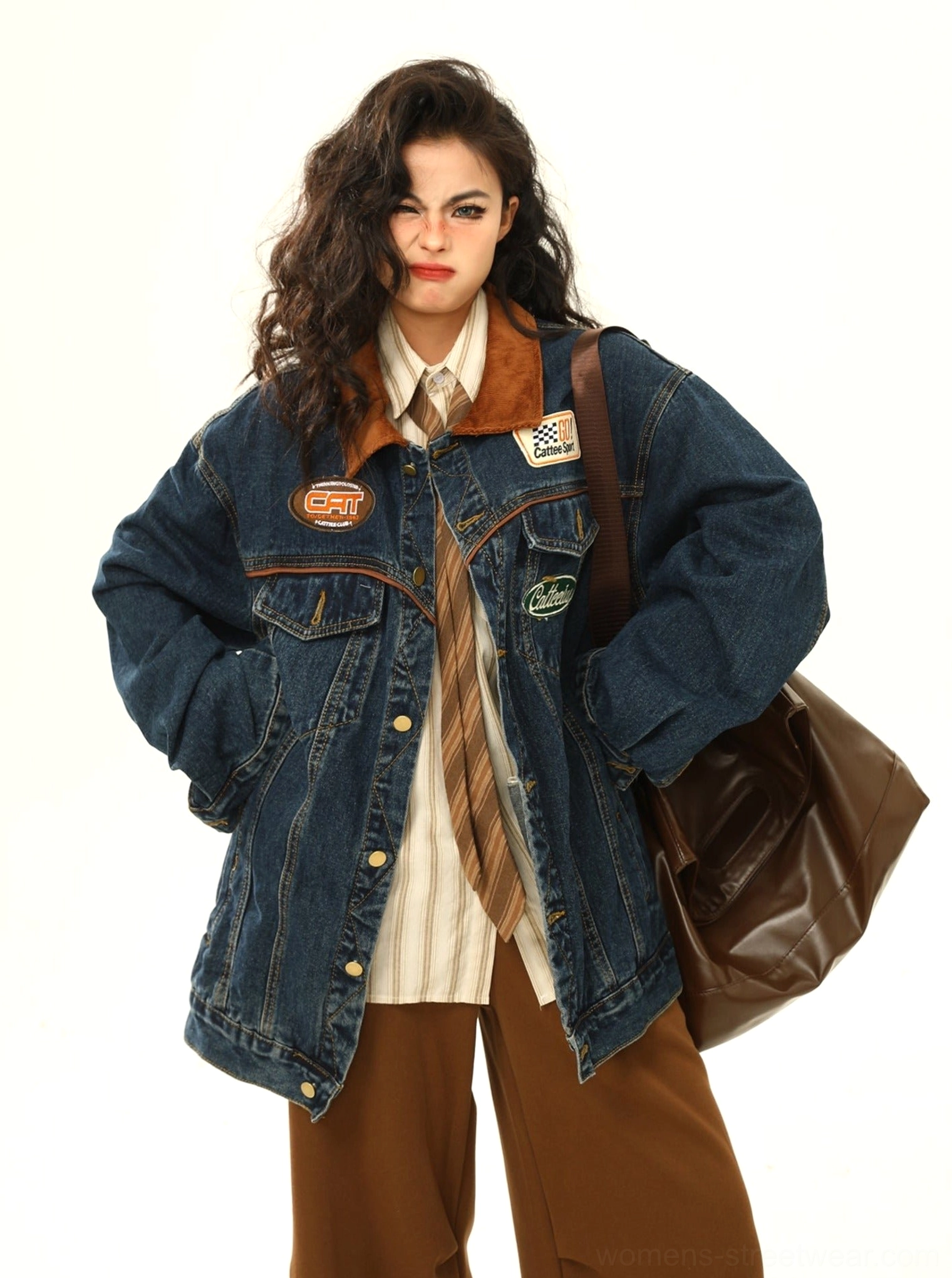 Full-body view of women's dark wash racing patch denim jacket with corduroy collar and chest patches styled with brown clothing