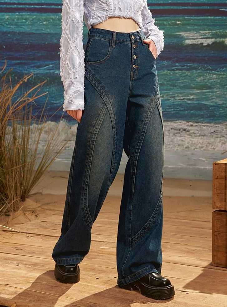Side front full body view of women's high waist dark wash retro wide leg denim jeans with curved seam construction