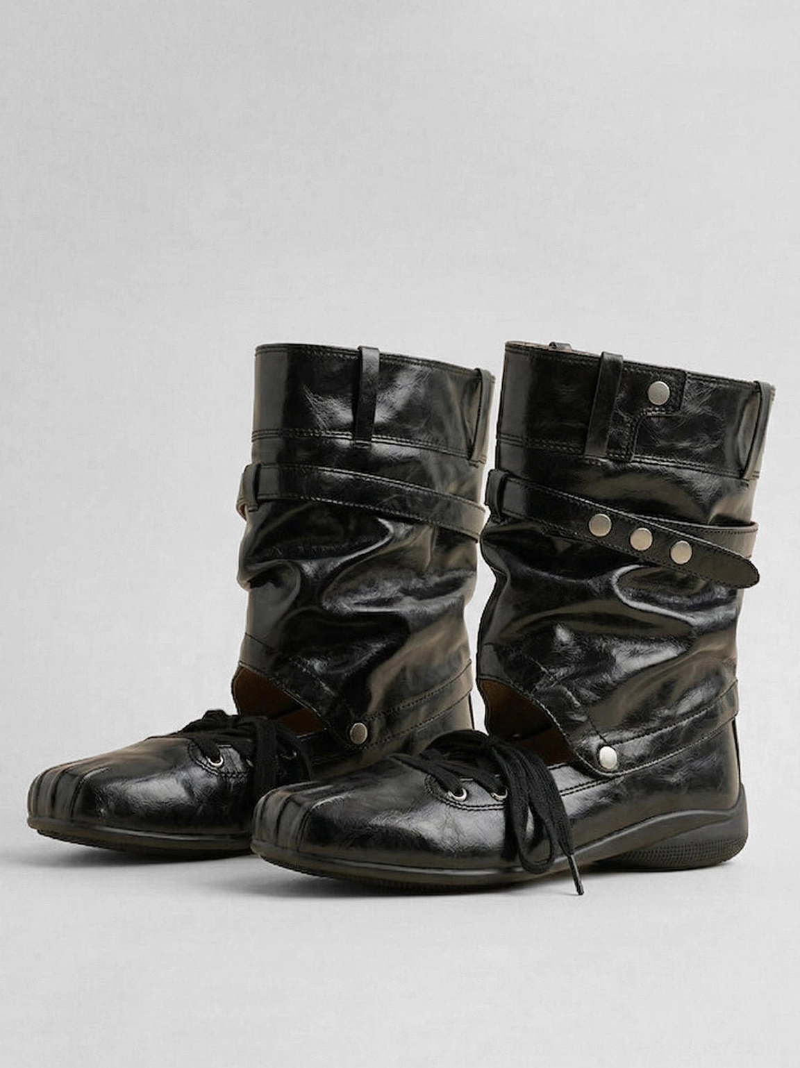 Front three-quarter view of women's black cutout square-toe utility boots with slouchy shaft and layered straps
