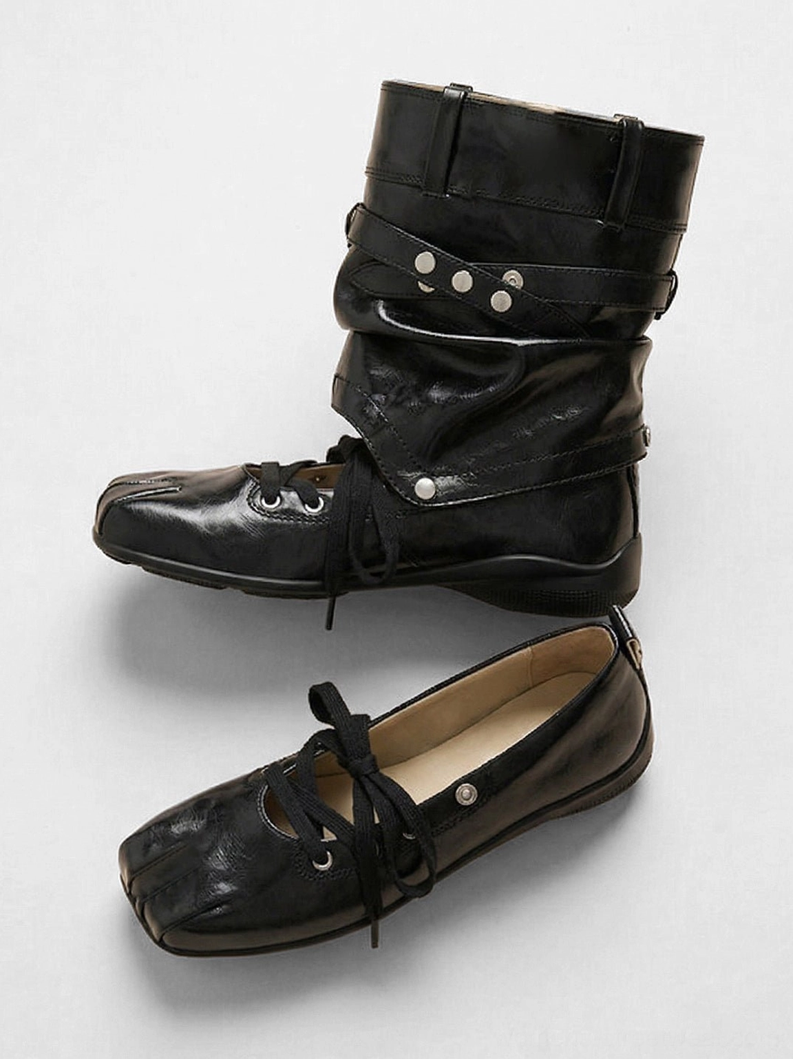 Top three-quarter product view of women's black square-toe cutout utility boots with lace-up and strap hardware