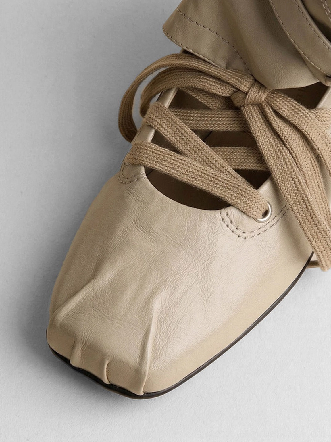 Women's detachable bow cutout square-toe utility boots showing low utility sole and square toe profile