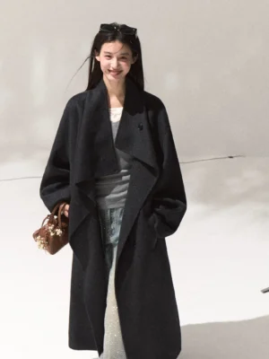 Women's dark navy draped wool longline overcoat with oversized shawl lapel shown in a full body studio outfit