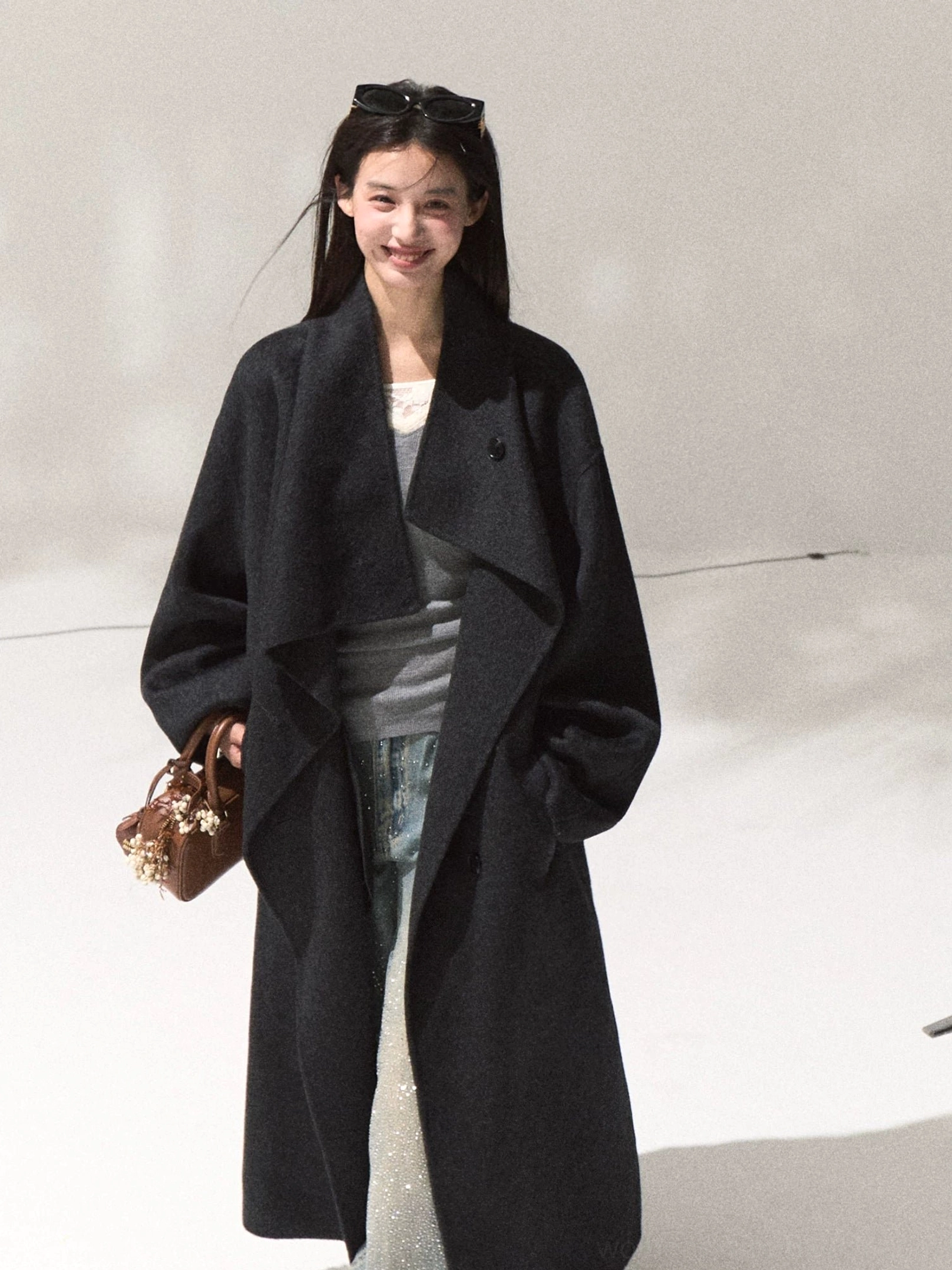 Women's dark navy draped wool longline overcoat with oversized shawl lapel shown in a full body studio outfit