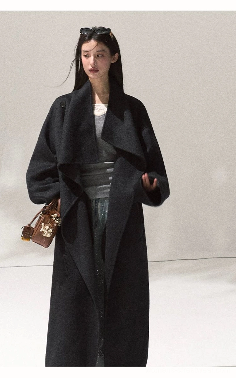 Women's dark navy oversized draped wool longline overcoat styled with a brown floral embellished handbag
