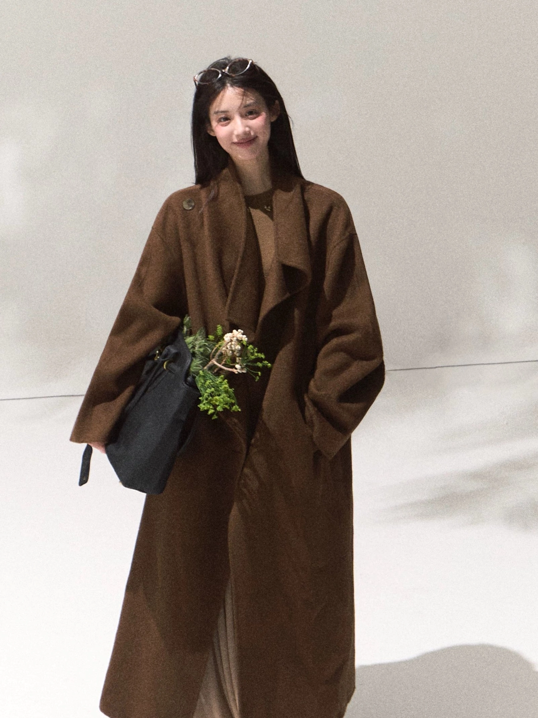 Women's draped wool longline overcoat showcasing oversized silhouette and refined Seoul streetwear design