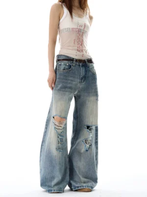Women's faded blue distressed wide leg jeans with brown belt and shredded knee details