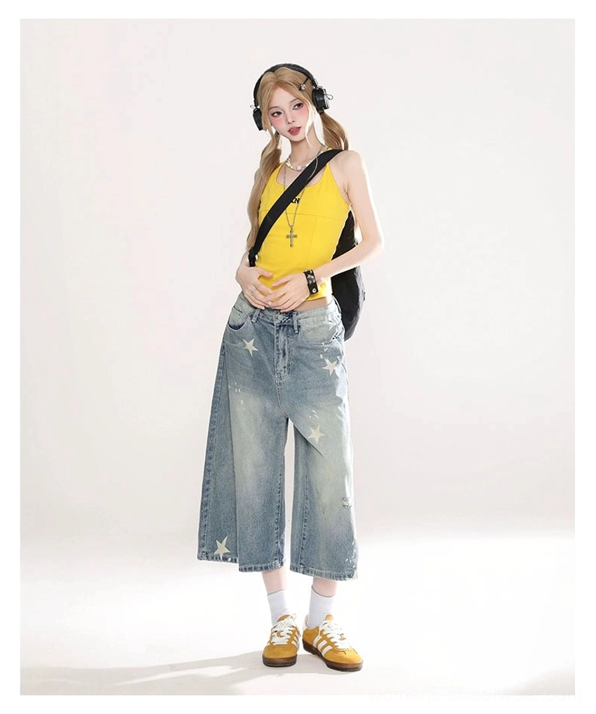 Three quarter view of women's faded blue star print wide leg cropped jeans with relaxed streetwear fit