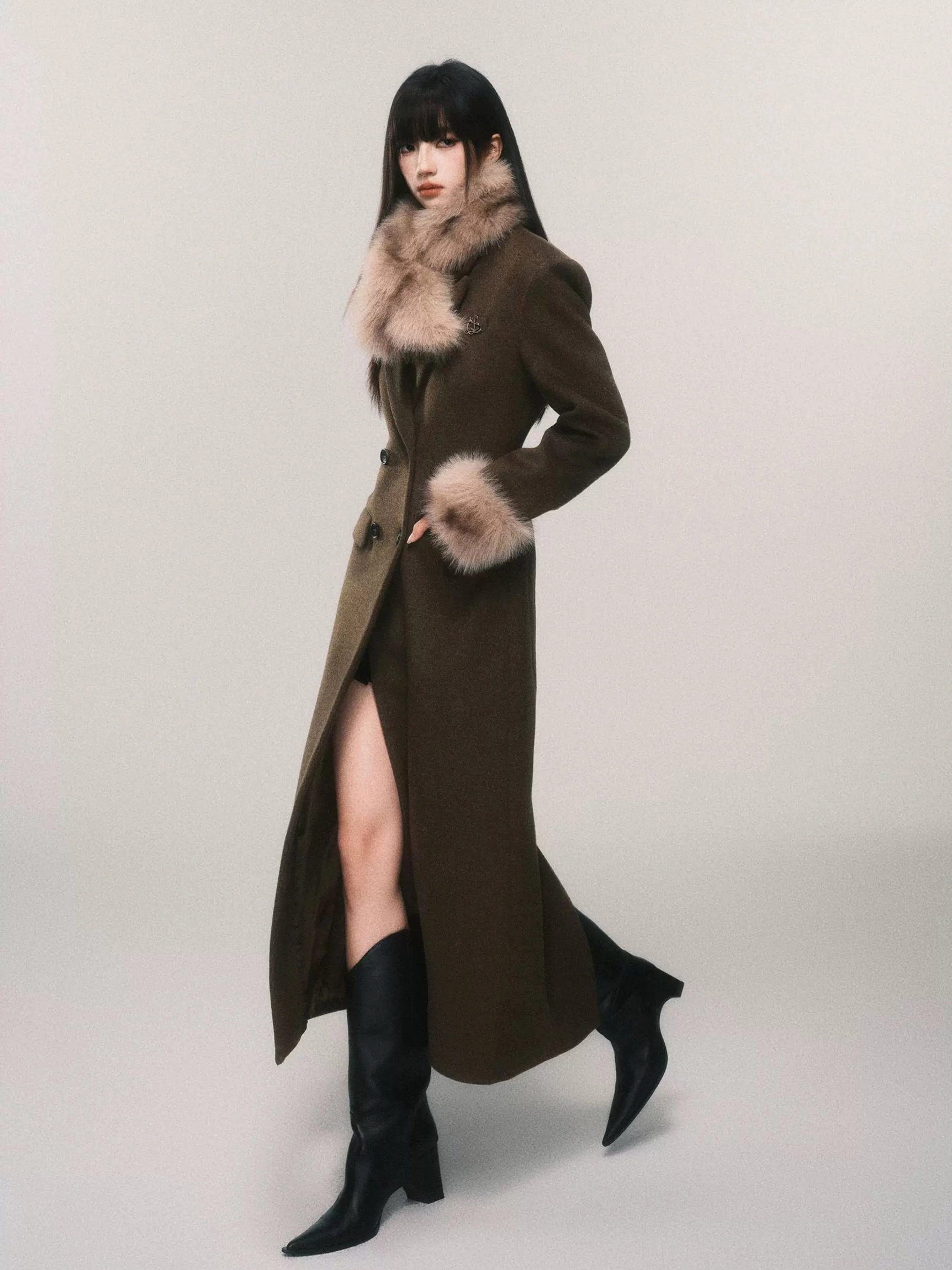 Women's tailored faux fur cuff maxi coat in side profile showing the long wool blend silhouette, shaped waist and rear hem vent