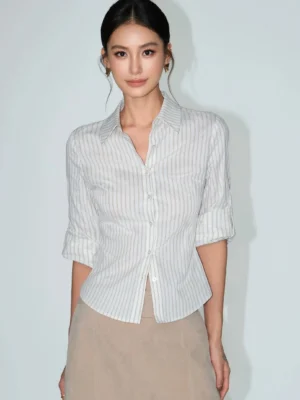 Close-up front view of a women's fitted pinstripe button-up shirt with neat collar, button placket, and rolled three-quarter sleeves