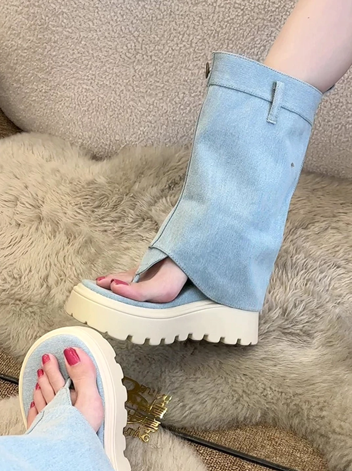 Close-up of light blue textile thong platform Roman sandal boot with fold-over button cuff