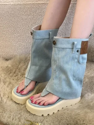 Model wearing light blue fold-over thong platform Roman sandal boots with chunky white platform soles