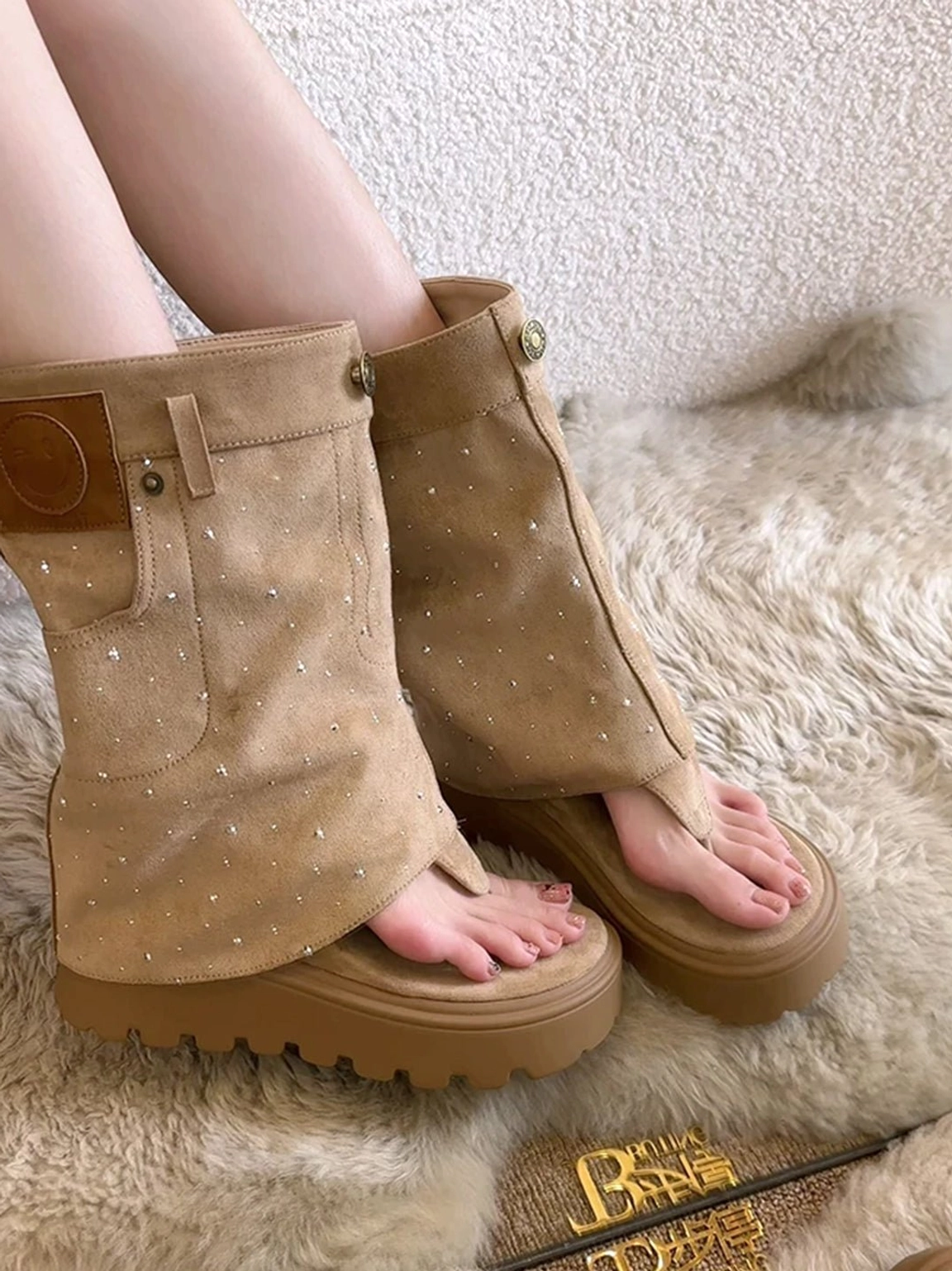 Model wearing khaki fold-over thong platform Roman sandal boots with thick brown platform soles