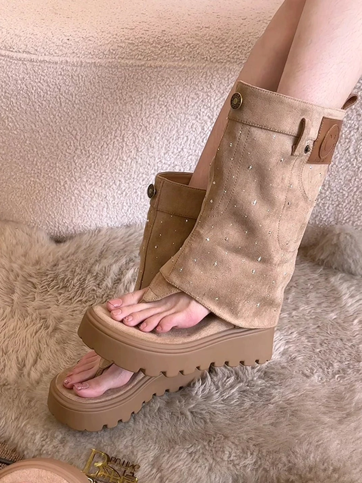Khaki platform thong sandal boots worn on model featuring fold-over shafts and leather patch detail
