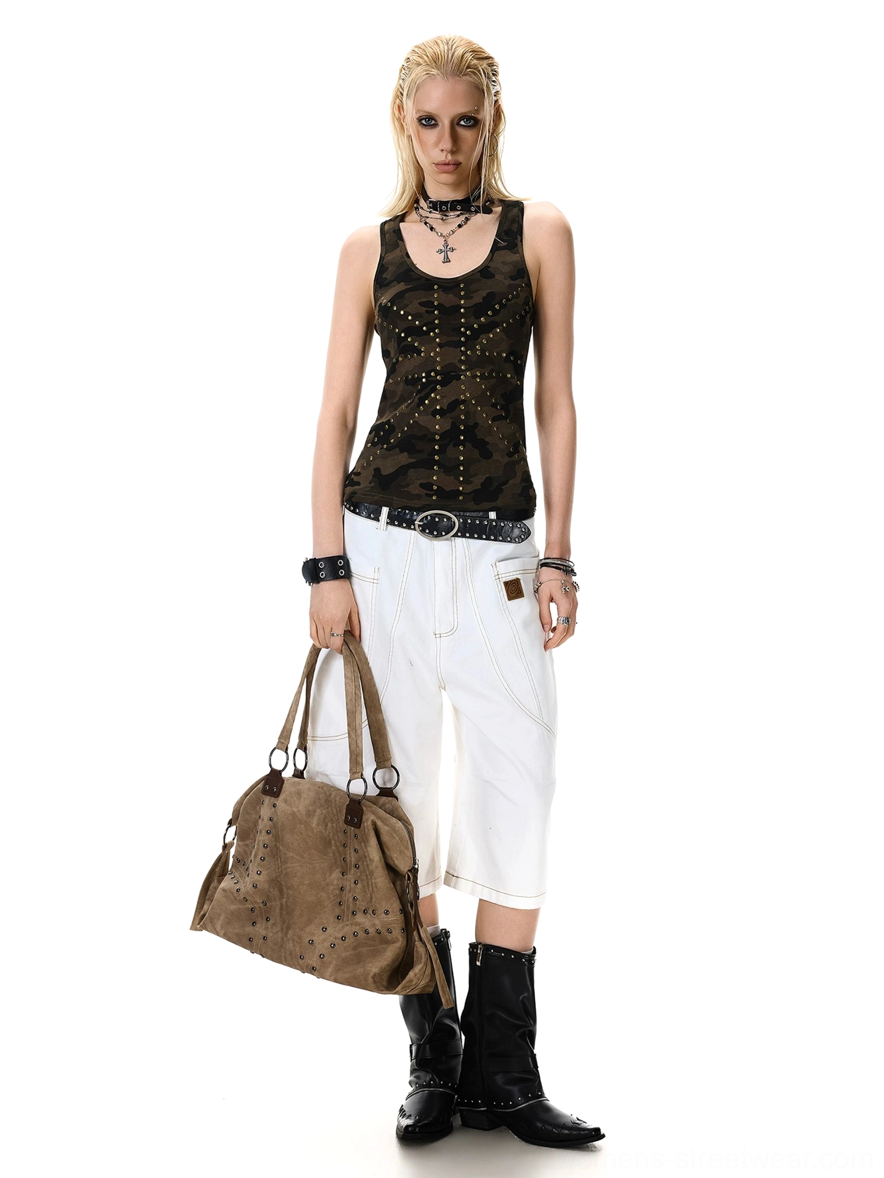 Full-length women's studded camo tank top with full metal stud coverage styled with white cropped pants, black boots, and a brown tote bag
