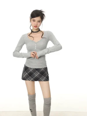 Women's gray ribbed button V-neck Henley long sleeve slim fit top styled with plaid mini skirt