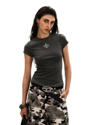 Women's gray slim fit cross embroidered baby tee styled with camouflage cargo pants in a white studio