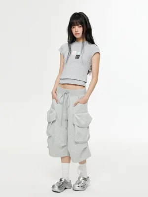 Three-quarter front view of women’s heather gray loose fit cargo Bermuda shorts with drawstring elastic waist