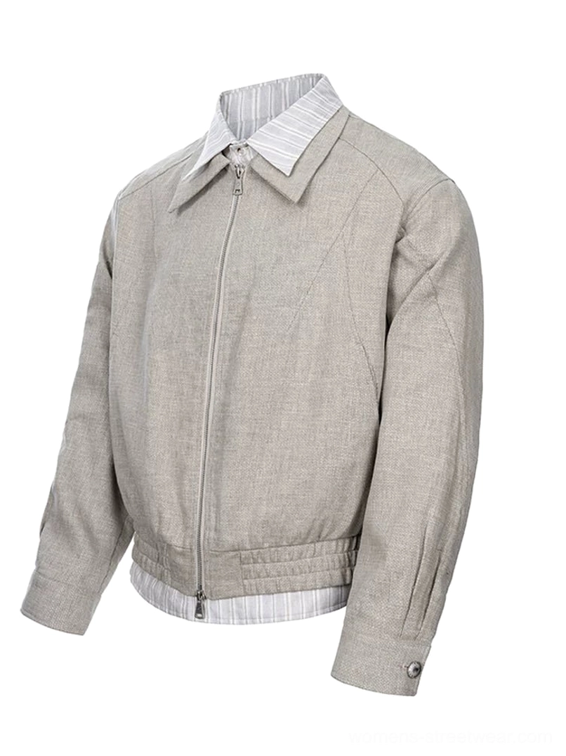 Three-quarter view of a relaxed cropped linen cotton streetwear jacket showing the striped shirt-style underlayer, shoulder seams, and metal zipper