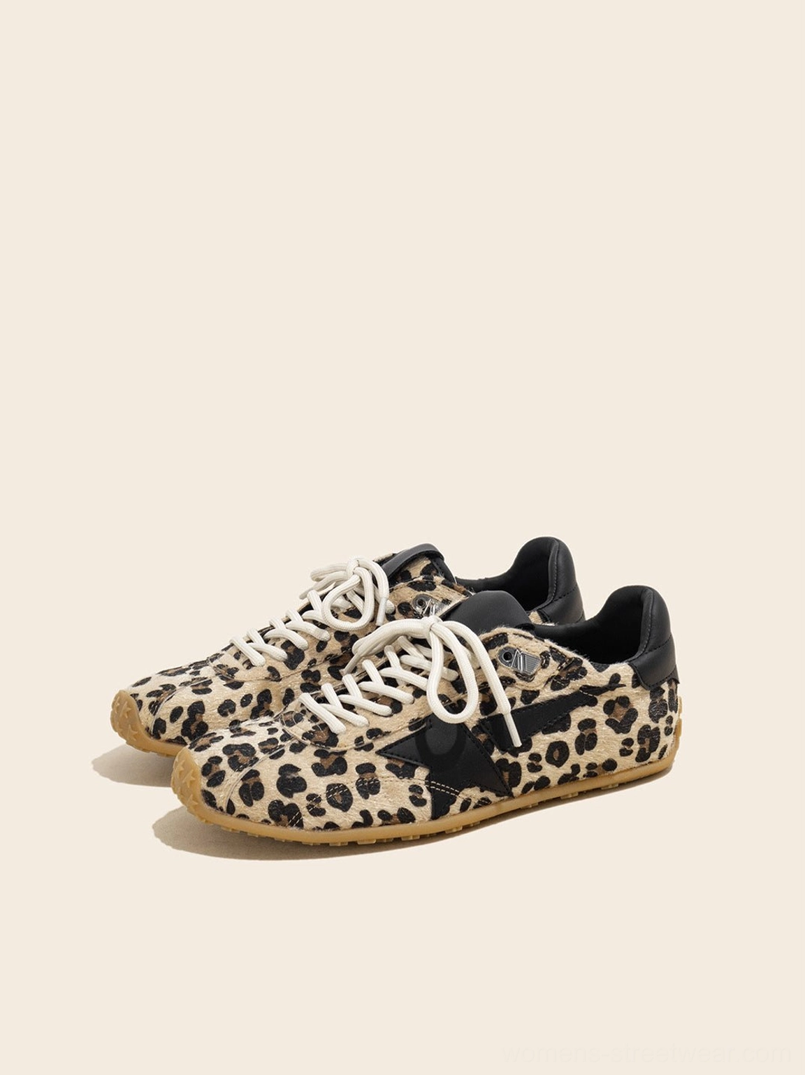 Three-quarter view of women's leopard suede star low-profile retro trainers showing black side star patch and gum sole
