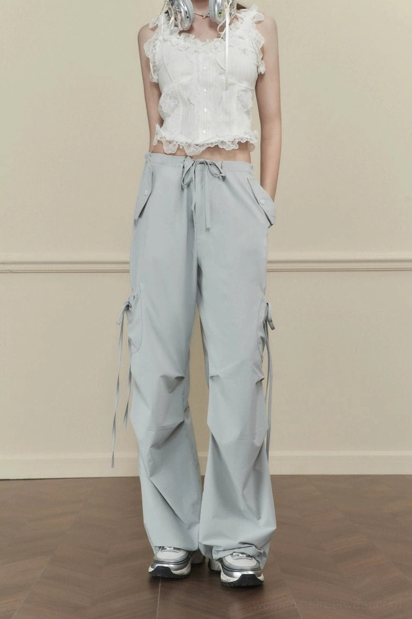 Women's light gray loose-fit wide-leg cargo pants with drawstring waist side pockets and long decorative tie straps