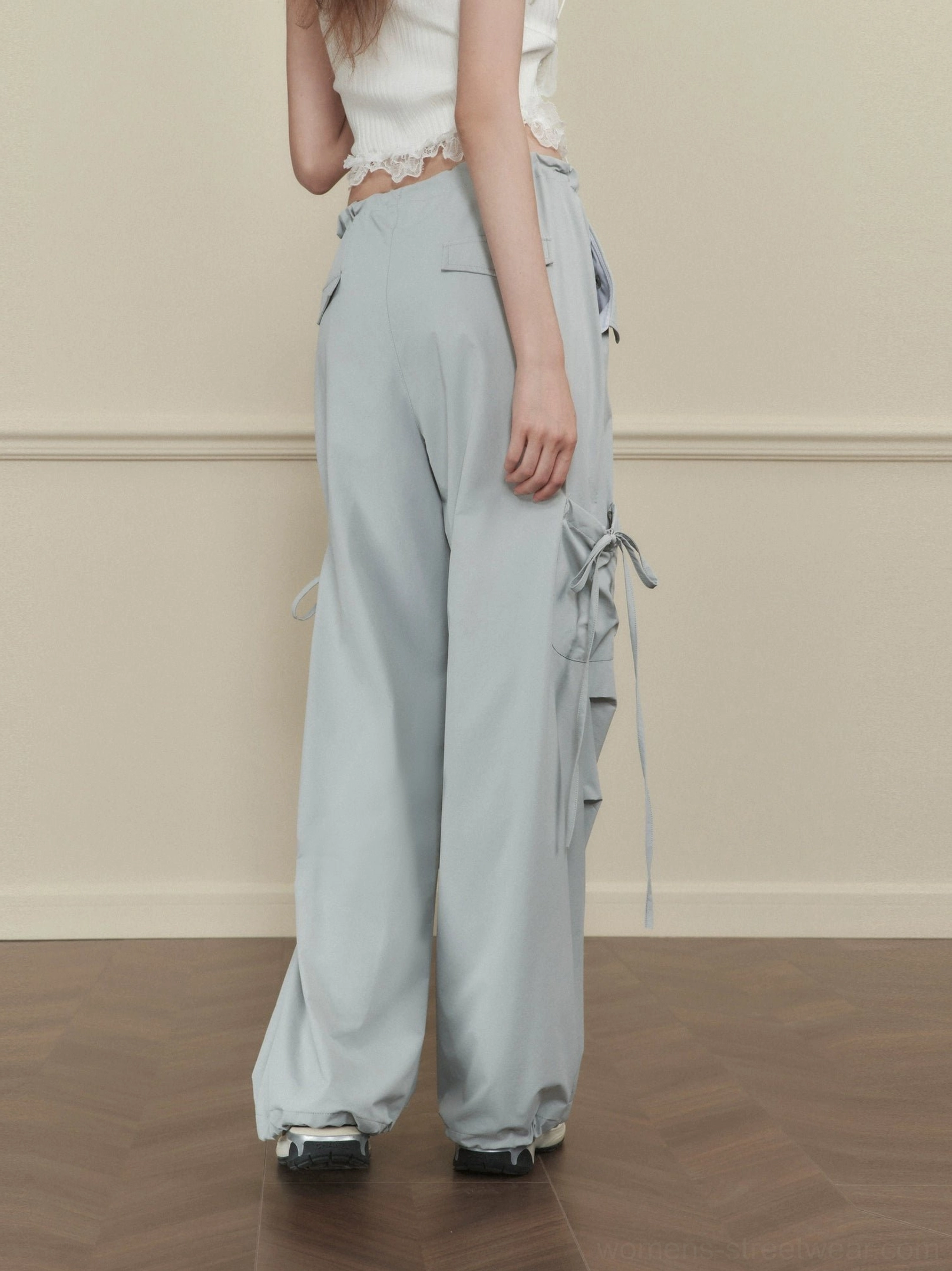 Women's light gray side-tie wide-leg cargo pants rear side view showing drawstring waist cargo pockets and long tie straps