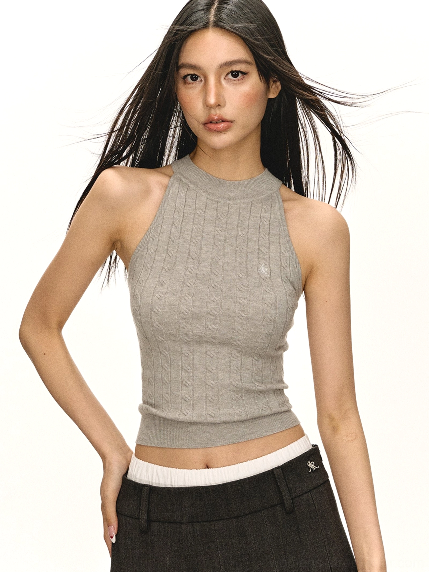 Light grey fitted cropped cable knit mock neck tank top for women with subtle chest logo styled with low-rise trousers