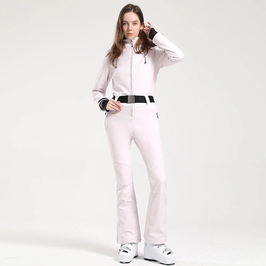 Women's light pink hooded flared ski jumpsuit with black belt and circular embroidered sleeve patch