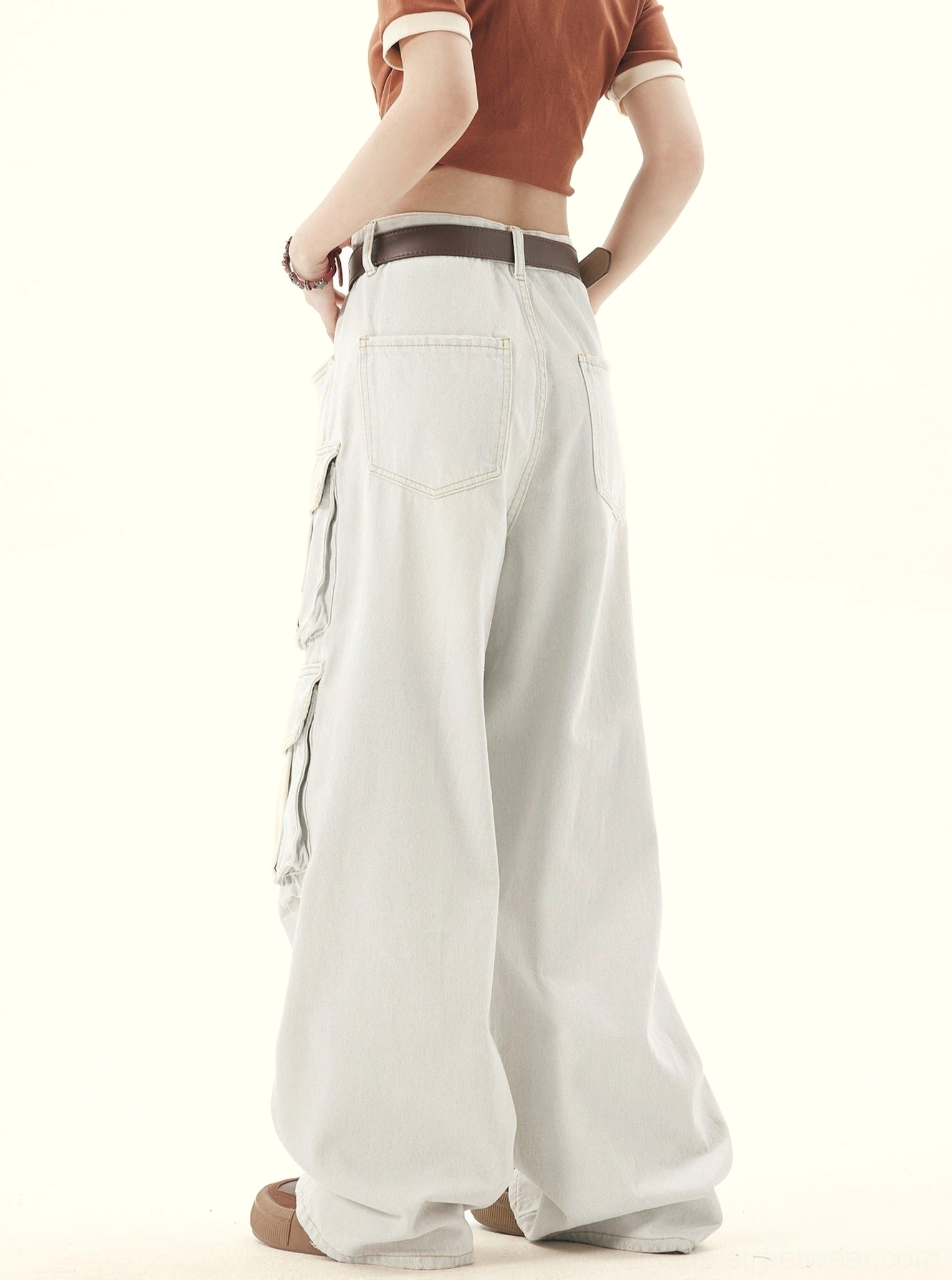 Right rear side view of women’s light wash wide leg denim cargo pants with faded utility pocket details