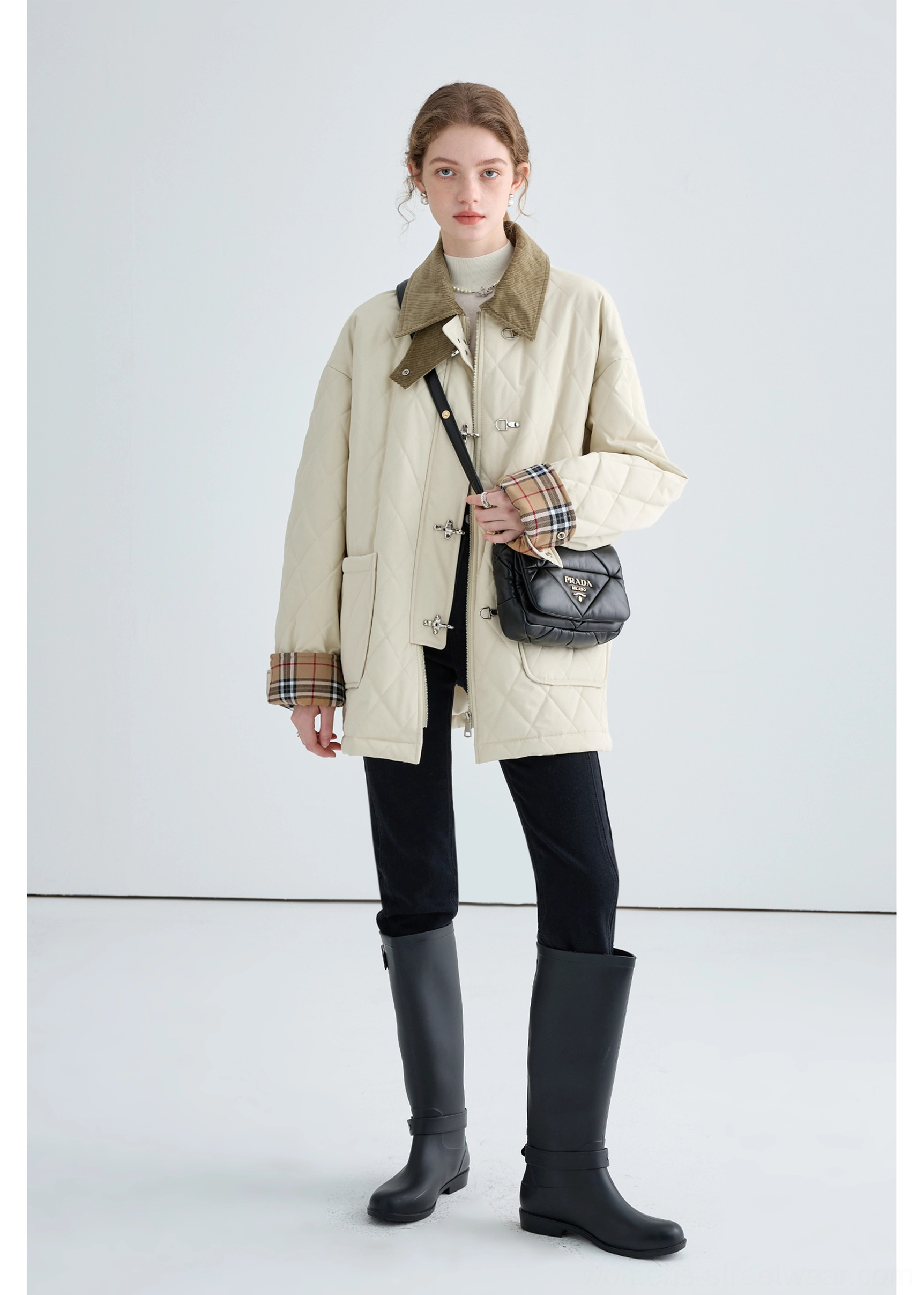 Women's long beige diamond quilted jacket with contrast collar and metal buckle closures styled with black boots