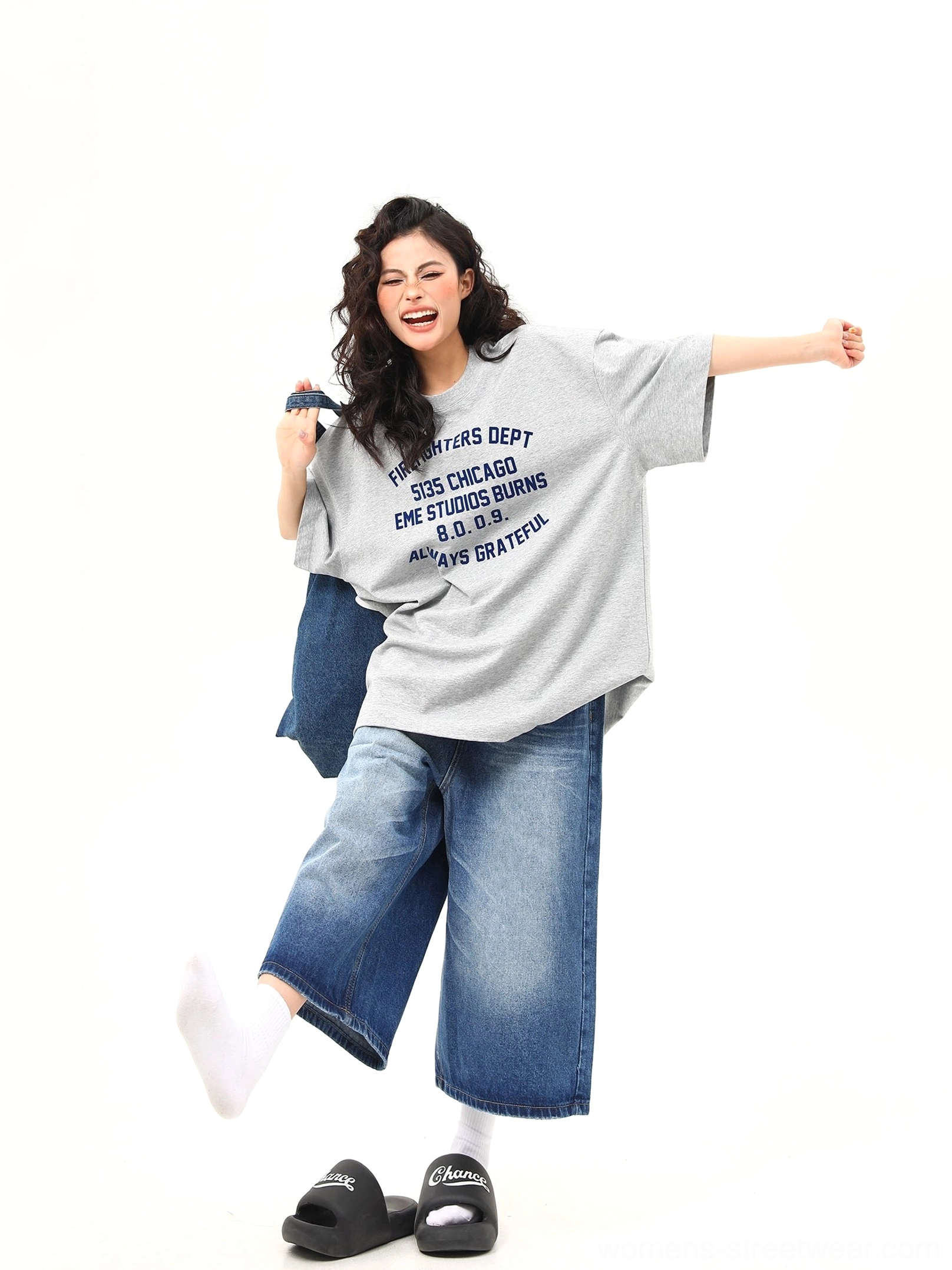 Side view of women’s loose fit gray Chicago graphic streetwear T-shirt styled with wide leg jeans