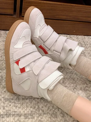 Women's multi-strap hidden-wedge high-top sneakers worn with beige crew socks, showing the light gray white and red streetwear color-block design