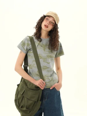 Women’s muted gray and olive camo cropped slim fit streetwear tee front three-quarter view with denim shorts