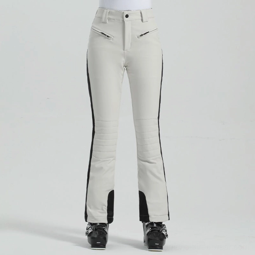 Off-white women's slim fit ski pants with black side stripes, zip pockets, flared cuffs, and technical winter styling