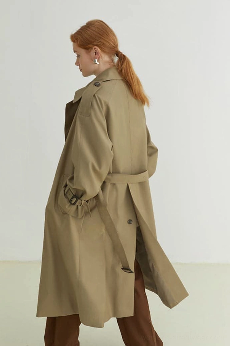 Women's khaki oversized belted trench coat side view showing longline silhouette and back slit
